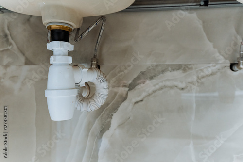 In a typical bathroom, there is a sink that features a drain pipe underneath it, essential for proper waste disposal and water drainage, contributing to the plumbing system of the house