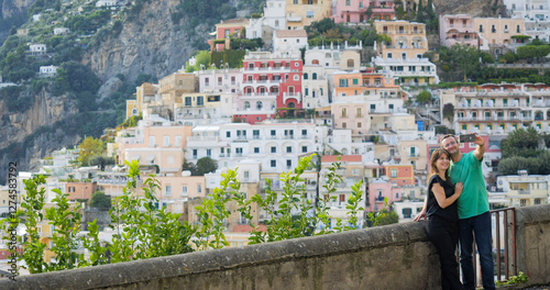 Man and woman takes selfies in front of Positano on Amalfi coast, Italy