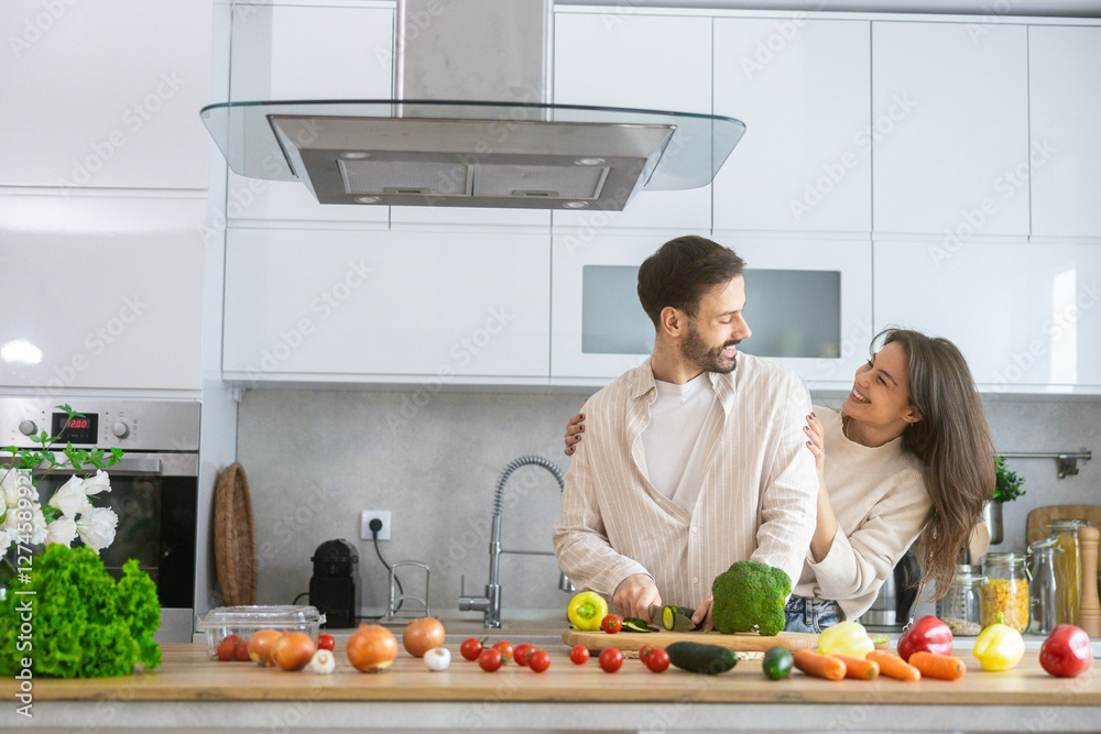 A couple happily engaged in food preparation, showcasing togetherness and love in their contemporary kitchen space. A couple happily engaged in food preparation, showcasing togetherness and love in their contemporary kitchen space.