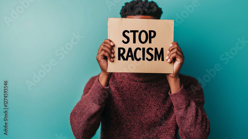 Activist holding a cardboard sign with the inscription stop racism during a demonstration against racial discrimination photo