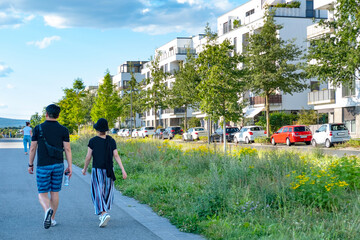 people walking around residential buildings, community with lush greenery, modern architecture and well-maintained landscape, apartment buildings, Frankfurt - August 25 2024