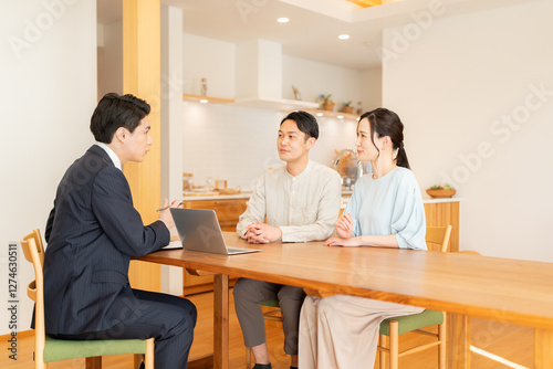 スーツ姿のビジネスマンに営業を受ける夫婦