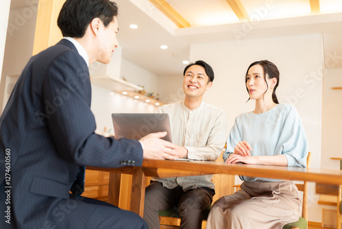 スーツ姿のビジネスマンに営業を受ける夫婦
