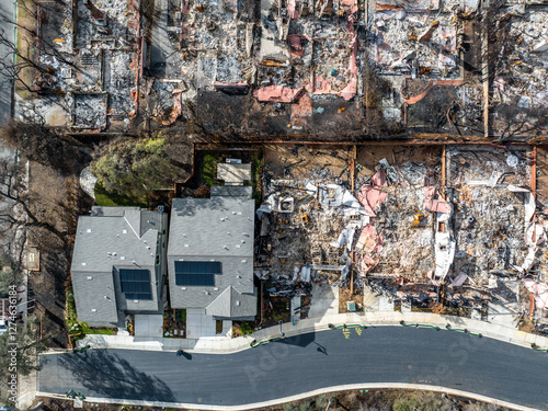 Aerial view of the Eaton Fire destruction in Altadena, California, showing entire neighborhoods devastated by wildfire alongside surviving homes and streets