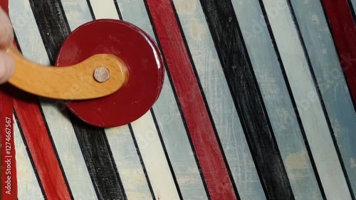 man turns the wooden handle of a barrel organ