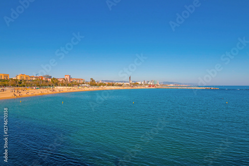 Port Olímpic Marina in Barcelona on a sunny day, featuring luxury yachts, clear blue skies, and a vibrant waterfront atmosphere along the Mediterranean coast. photo