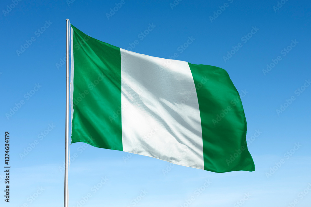 Obraz premium Waving Nigerian flag, national symbol, blue sky