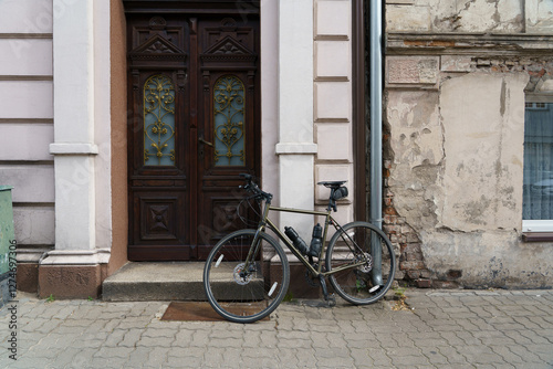 Obraz na płótnie Road bicycle with slim steel frame in front of an old destroyed brick wall next to renovated vintage baroque facade with entrance door. w salonie