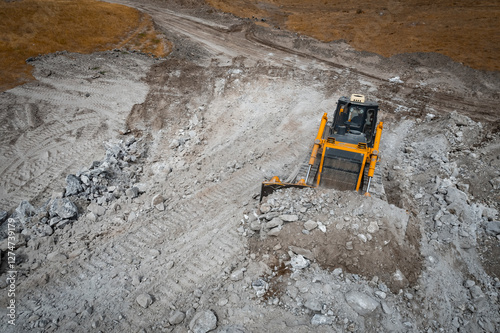 Bulldozer is doing its job at gypsum mining quarry photo