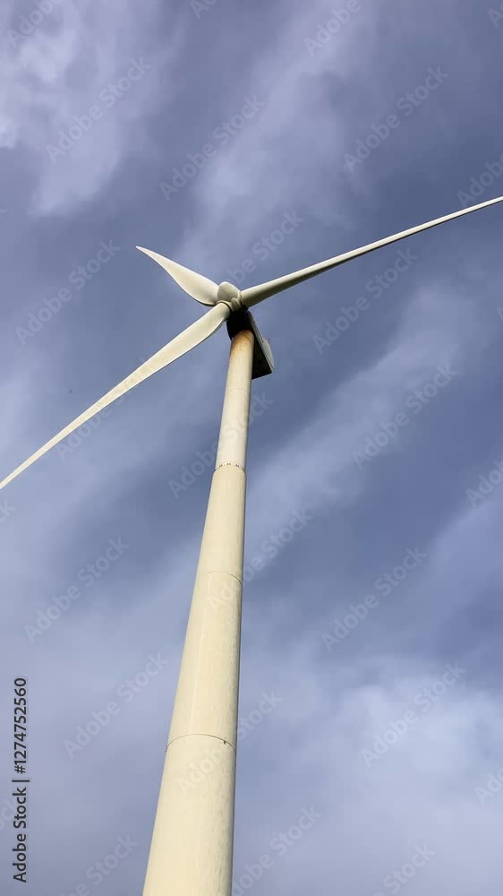 A windmill standing in a field of barley, its blades turning slowly in the wind, Andalusia, Spain A windmill standing in a field of barley, its blades turning slowly in the wind, Andalusia, Spain