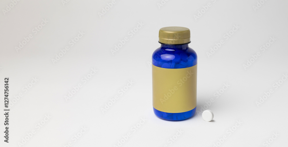 Mockup of a magnesium bottle with a pill on the side, food supplement, closed, blue color, with label, on white background with copyspace Mockup of a magnesium bottle with a pill on the side, food supplement, closed, blue color, with label, on white background with copyspace