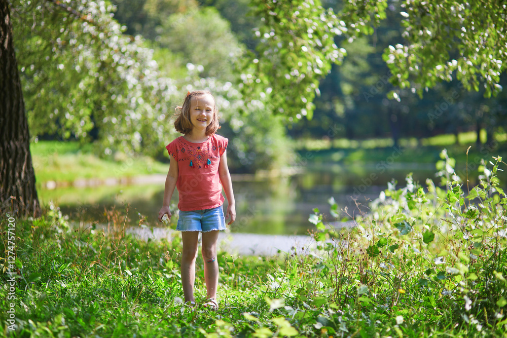Adorable preschooler girl having fun in a green park on a summer day. Adorable preschooler girl having fun in a green park on a summer day.