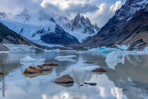 Majestic snow-capped mountains Cerro Torre in Patagonia, Argentina, El Chalten, tower over a glacial lake with floating icebergs. The dramatic landscape, rugged peaks at Laguna Torre in the Andes