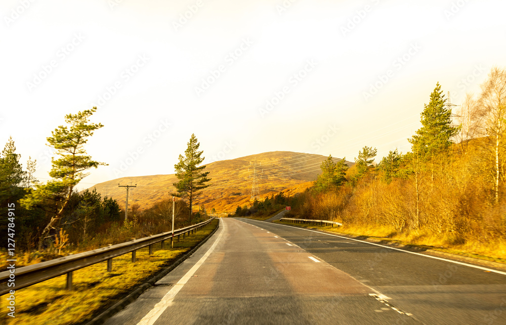Obraz premium A Scottish Highland Road Taking Vehicles Through The Most Stunning Scenery