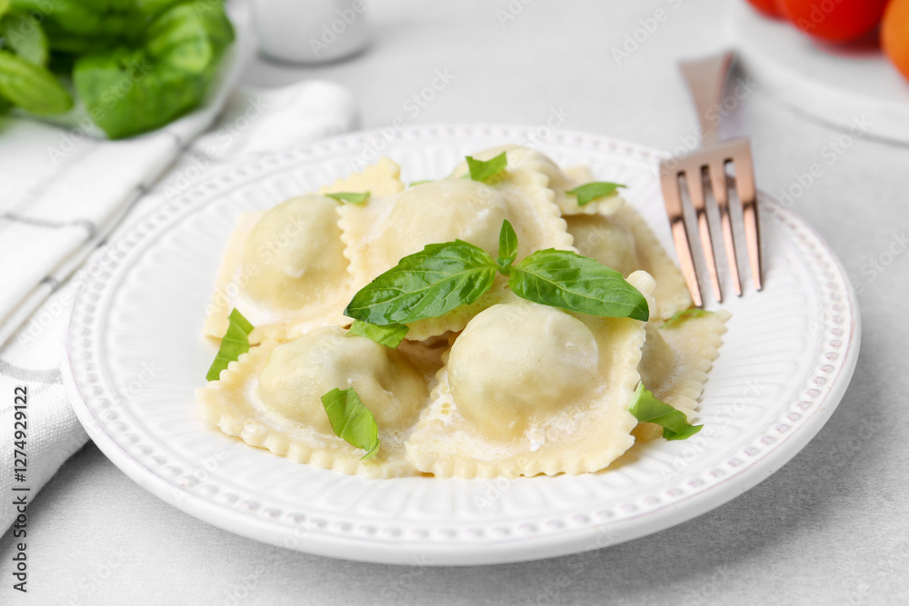 Delicious ravioli with cheese and basil served on light table, closeup Delicious ravioli with cheese and basil served on light table, closeup