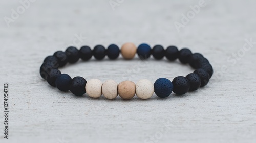 A beaded bracelet featuring a mix of black, beige, and blue beads arranged in a pattern. photo