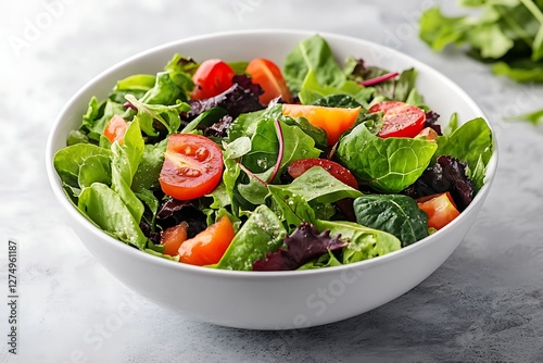 Fresh mixed greens salad in white bowl on marble photo