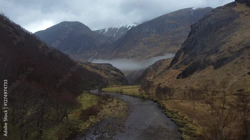 Cinematic drone shot through valley looking up at Nevis hiding in the clouds from Glen Nevis valley, near Steall Waterfall, Scotland Cinematic drone shot through valley looking up at Nevis hiding in the clouds from Glen Nevis valley, near Steall Waterfall, Scotland