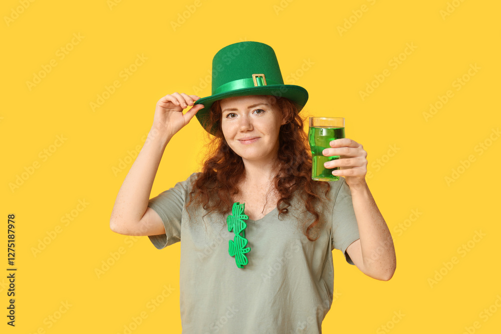 Young redhead woman in hat with beer on yellow background. St. Patrick's Day celebration