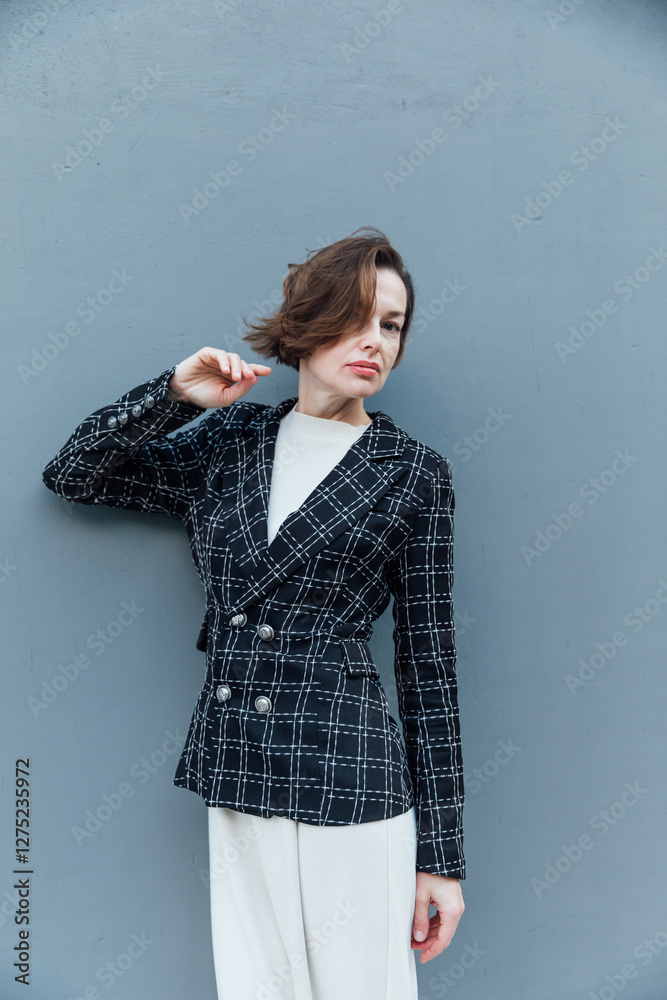 Beautiful woman of 40 years old in business suit on gray background Beautiful woman of 40 years old in business suit on gray background