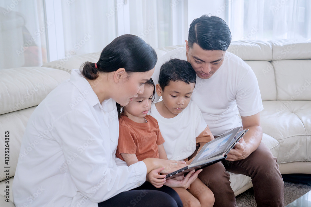 Loving Family Reading a Digital Book Together on a Tablet at Home Loving Family Reading a Digital Book Together on a Tablet at Home