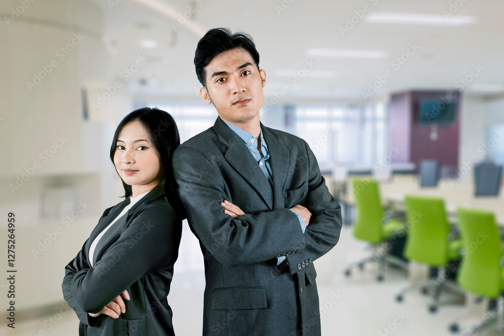 Confident Business Professionals Standing Back-to-Back in a Modern Office Confident Business Professionals Standing Back-to-Back in a Modern Office
