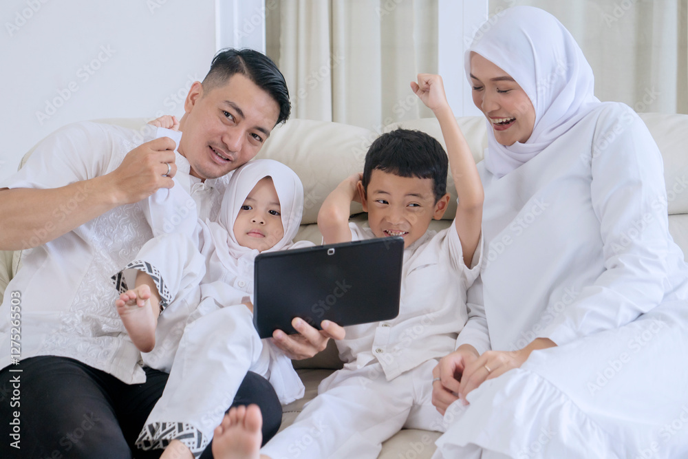 Excited Muslim Family Watching Content on Tablet Together at Home Excited Muslim Family Watching Content on Tablet Together at Home