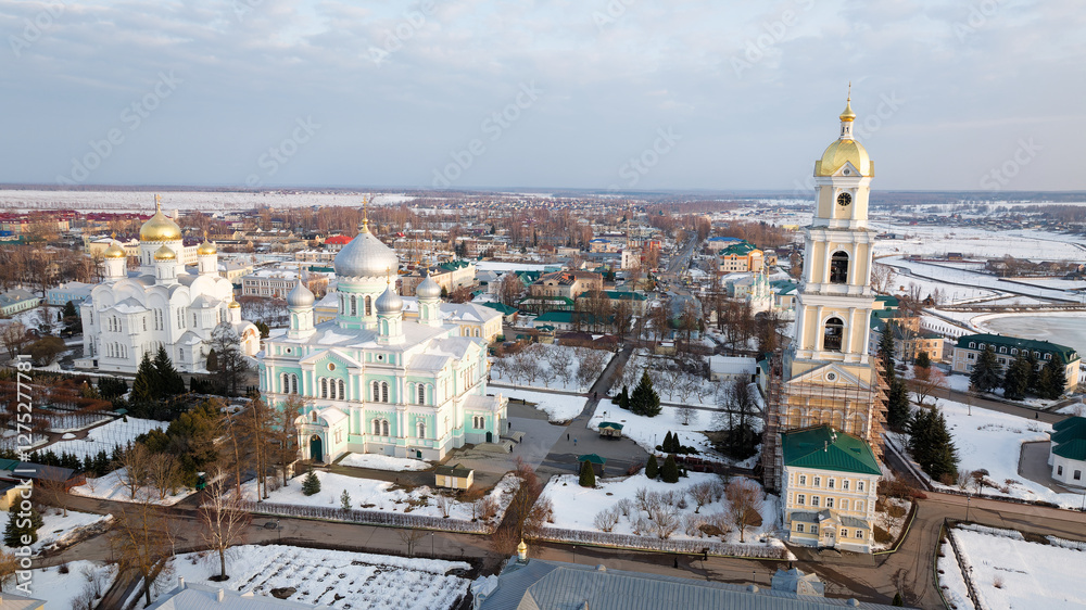 Fototapeta premium Snowy city with a large church and a tall bell tower