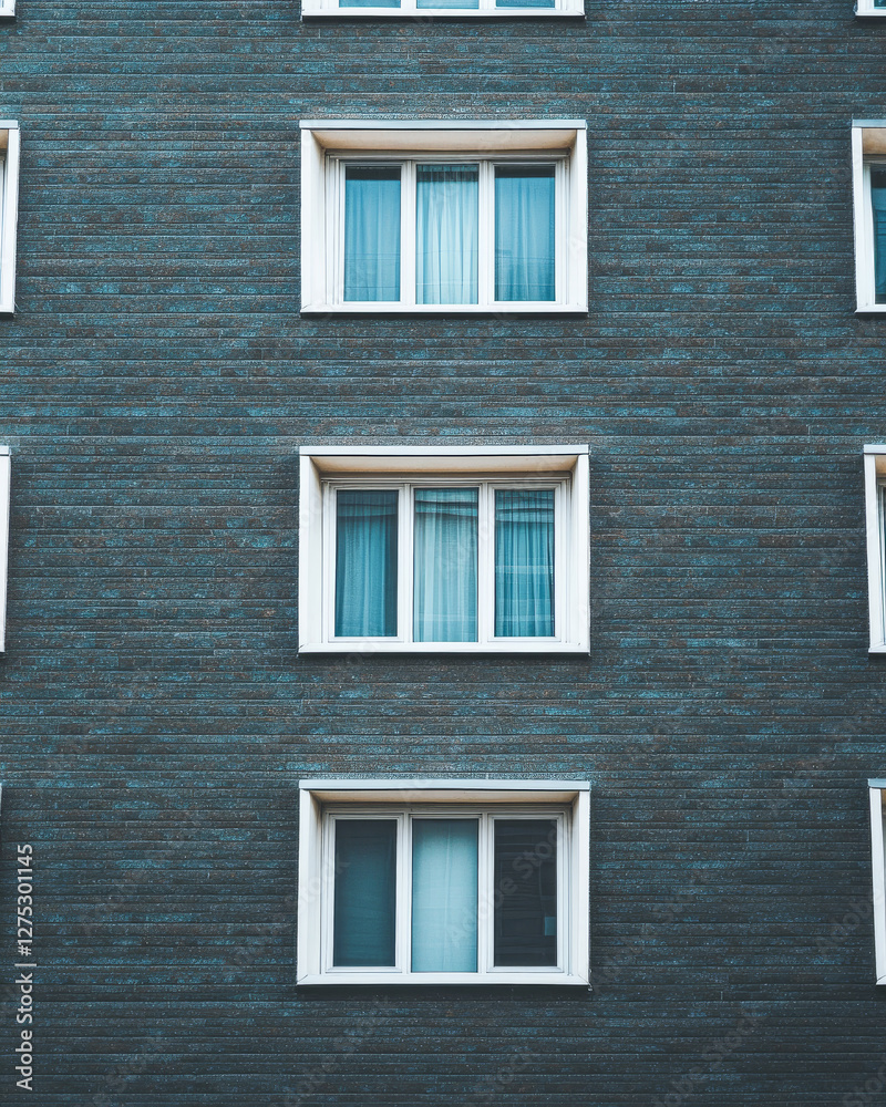 Modern building facade featuring multiple windows in an urban setting during daytime Modern building facade featuring multiple windows in an urban setting during daytime