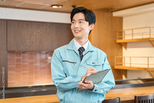 Photos 飲食店で点検をする作業着を着た男性