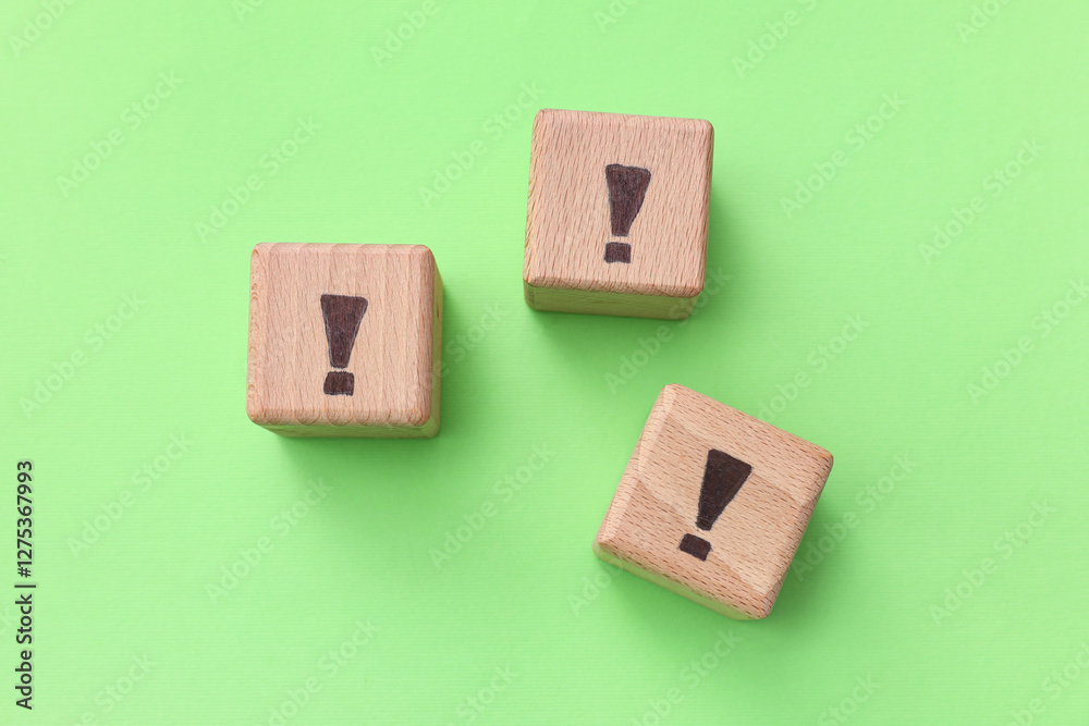 Wooden cubes with exclamation marks on green background Wooden cubes with exclamation marks on green background