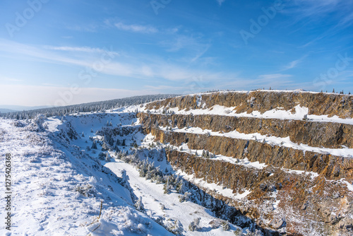 Fototapeta Naklejka Na Ścianę i Meble -  The snowy expanse of the Stanislaw Quartz Mine displays layers of rock amidst a winter wonderland, showcasing the rugged beauty of the Izera Mountains in Poland.