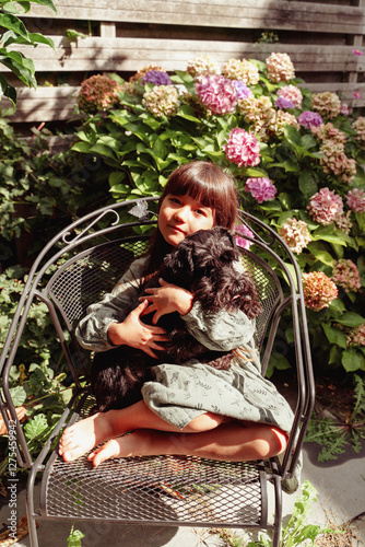 Little girl  with a dog in the garden photo