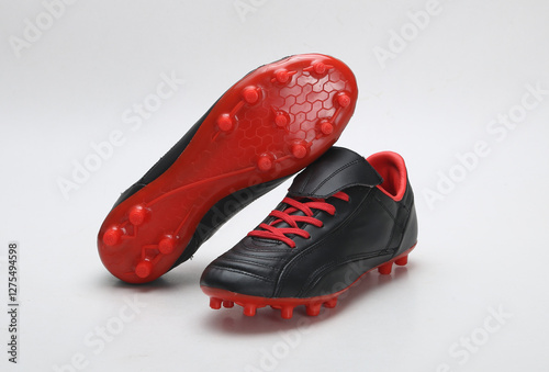 black and red color football shoes isolated on light background