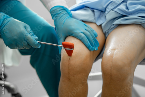 Asian doctor physiotherapist examining, massaging and treatment knee and leg of senior patient in orthopedist medical clinic nurse hospital.