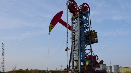 Against the backdrop of blue sky and white clouds, a pumping unit in a certain oil field is producing oil
