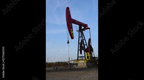 Against the backdrop of blue sky and white clouds, a pumping unit in a certain oil field is producing oil
