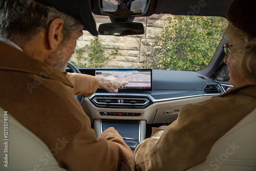 An elderly man pointing out something on the digital navigation system photo