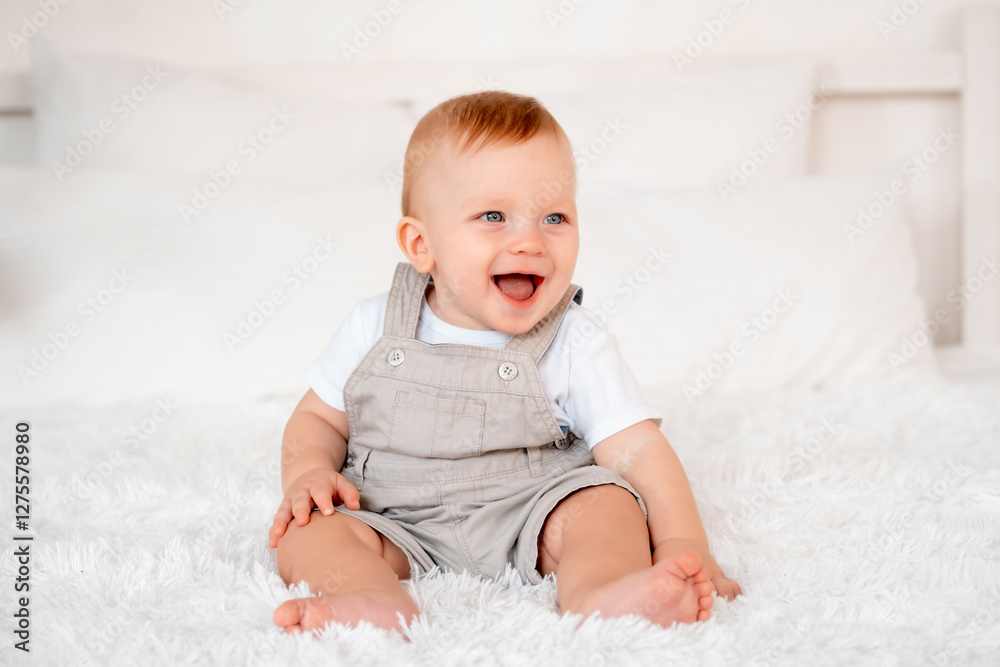 Happy baby boy laughing or smiling on the bed at home, joyful baby Happy baby boy laughing or smiling on the bed at home, joyful baby