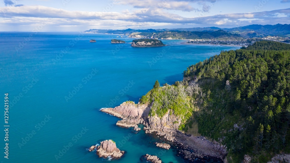 Naklejka premium Coastal Coromandel New Zealand scenery. Dramatic cliffs, turquoise water, and lush forest meet the ocean. Aerial view. , Whangamata, New Zealand