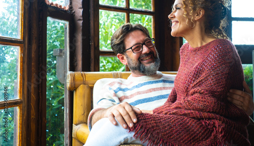 Mature couple cuddling and kissing indoors in a cozy mountain home, enjoying romantic moments together while on vacation, sharing love, affection, and intimacy in a warm and peaceful atmosphere