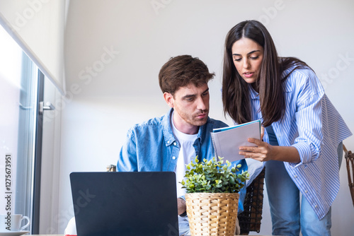 Canvastavla Worried people working from home, man analyzing numbers in notebook while woman