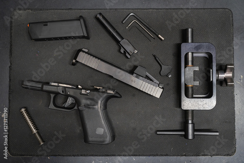 Installation and replacement of sights on a modern 9mm pistol in a workshop by a gunsmith.