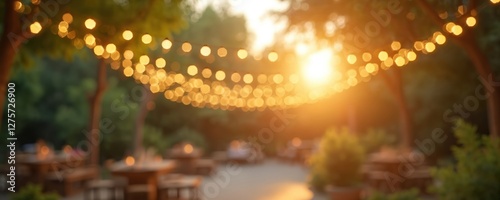 Blurred garden party background with warm lights. Summer evening with bokeh effect, relaxed atmosphere. Festive backyard with tables, decoration, and outdoor event concept.