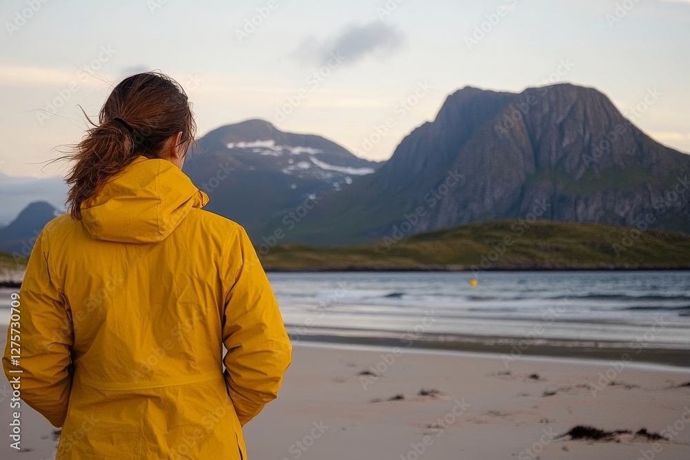 A woman on vacation in Norway's Lofoten islands takes in the sunset ocean view at Kvalvika beach, embracing a healthy lifestyle through eco-tourism and outdoor activities A woman on vacation in Norway's Lofoten islands takes in the sunset ocean view at Kvalvika beach, embracing a healthy lifestyle through eco-tourism and outdoor activities