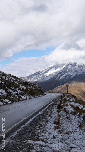 Vertical image of Ruta 107 on the way to Tunel Punta Olimpica with Cordillera Blanca snow capped mountain range in the background. Location:  East-central region of Ancash of Peru photo