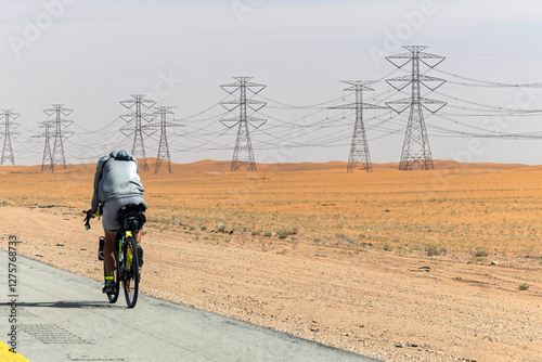 Cyclist with a saddle bag near Qatar Saudi border. Traveler on bicycle on sunny day photo