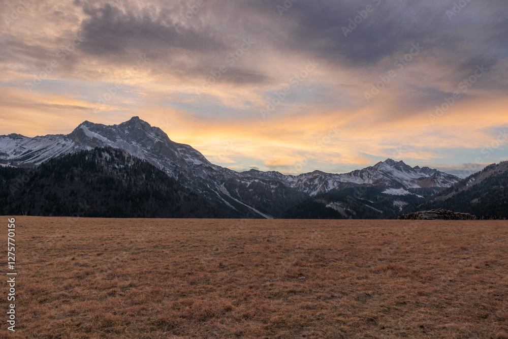 tramonto con cielo nuvoloso tra le montagne nel Friuli Venezia Giulia nord-occidentale, in Italia, in inverno