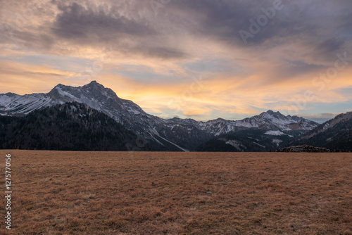 Obraz na płótnie tramonto con cielo nuvoloso tra le montagne nel Friuli Venezia Giulia nord-occidentale, in Italia, in inverno w salonie
