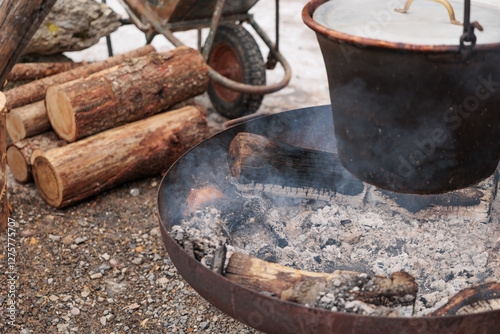 Obraz na płótnie grande pentola di metallo in cui viene cucinata della polenta alla brace, all'aperto, in inverno w salonie